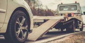 Loading broken car on a tow truck on a roadside